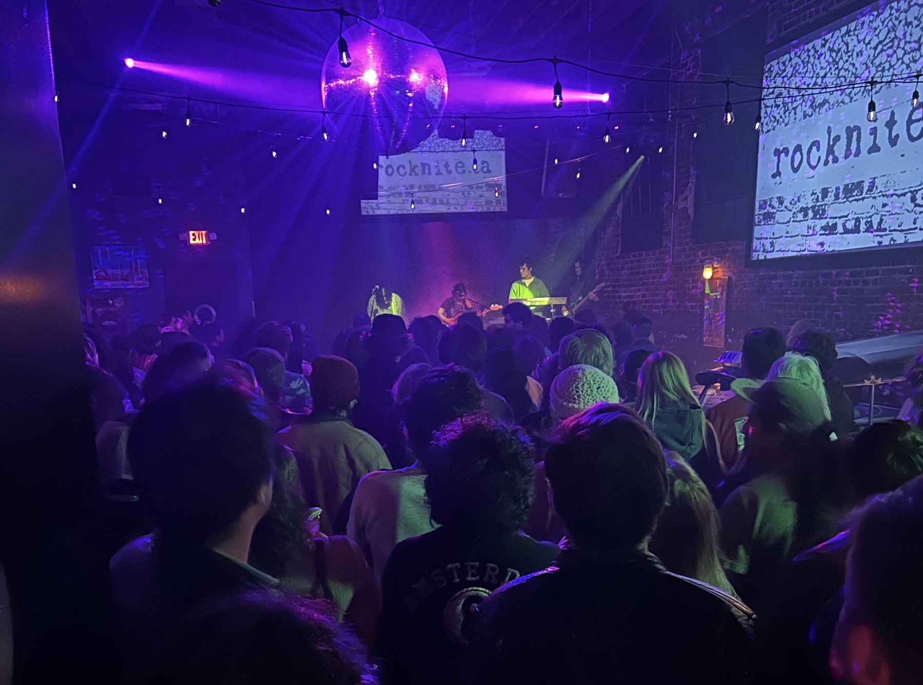 packed crowd at a rocknite show under a disco ball