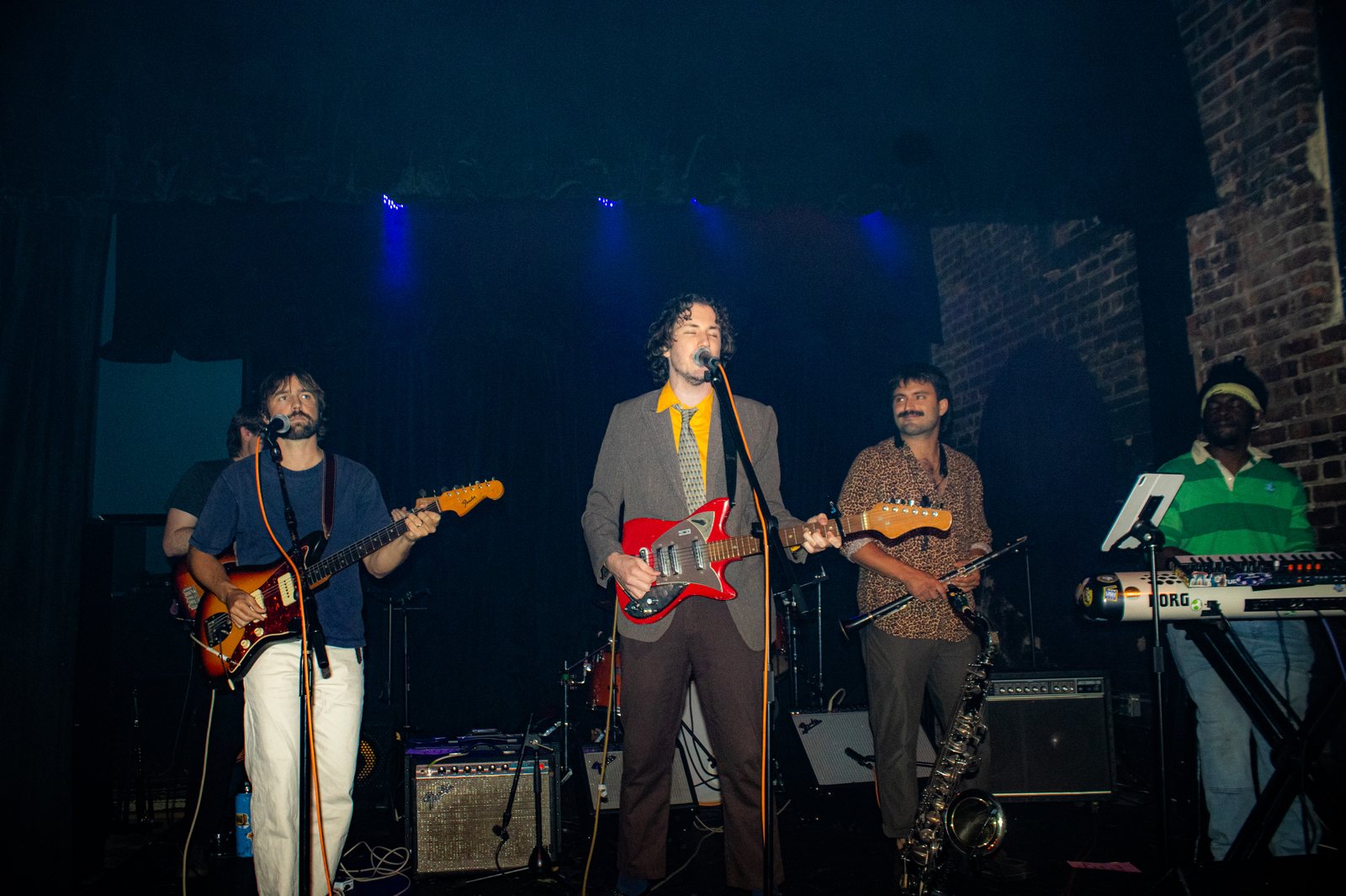 full band onstage with frontman holding a red guitar